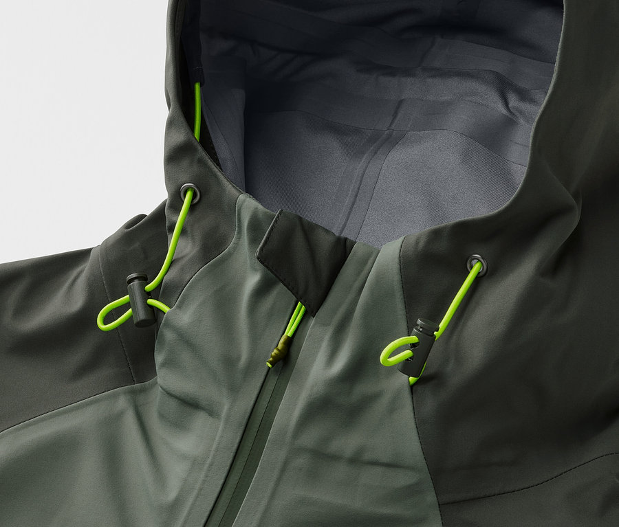 Gros plan sur une veste outdoor 3 couches kaki avec capuche et cordons de serrage vert néon.