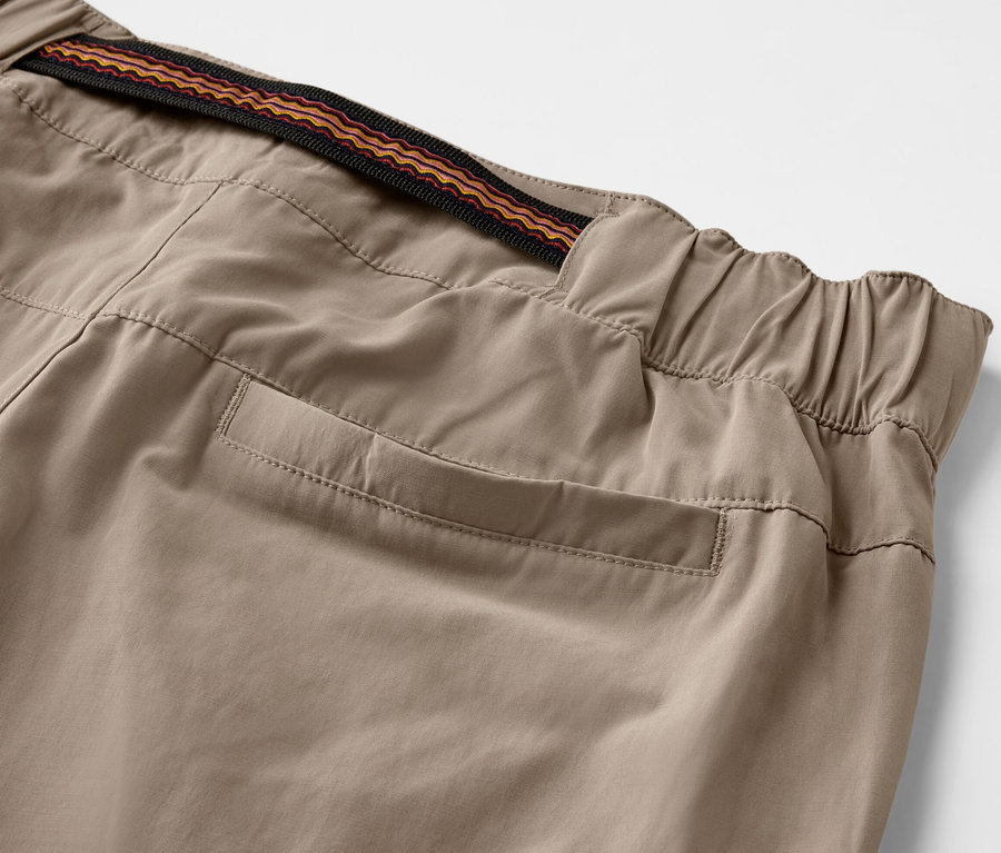 Gros plan sur un pantalon d’extérieur beige avec protection anti-moustiques, taille élastique et poche.