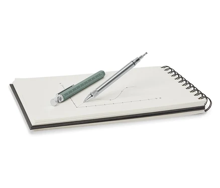 Un stylo multifonction vert et argenté posé sur un bloc-notes.