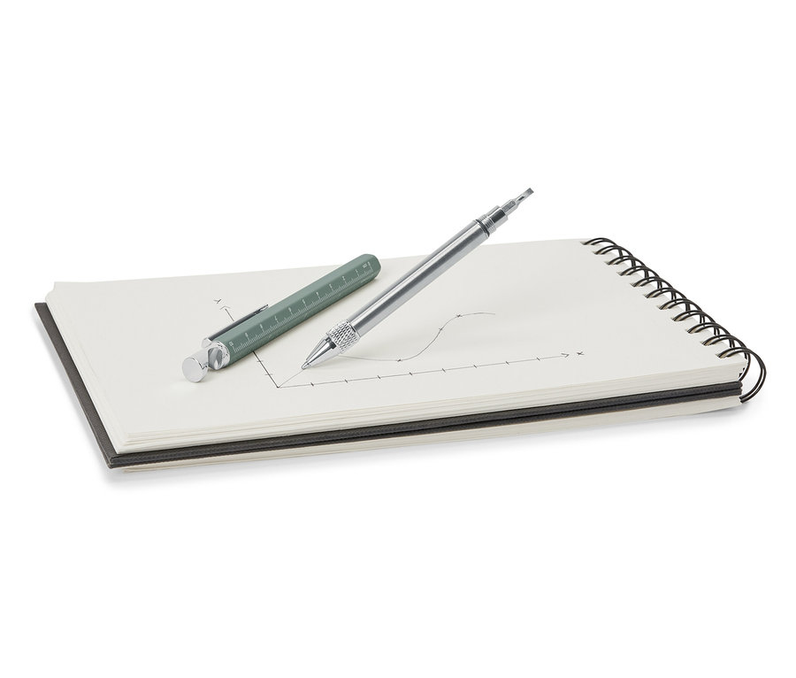 Un stylo multifonction vert et argenté posé sur un bloc-notes.