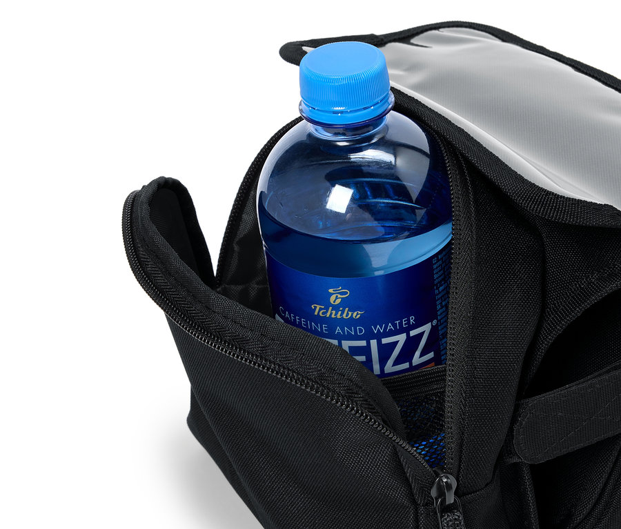 Une bouteille bleue de Tchibo Caffeine and Water Fizz est placée dans un sac noir ouvert.