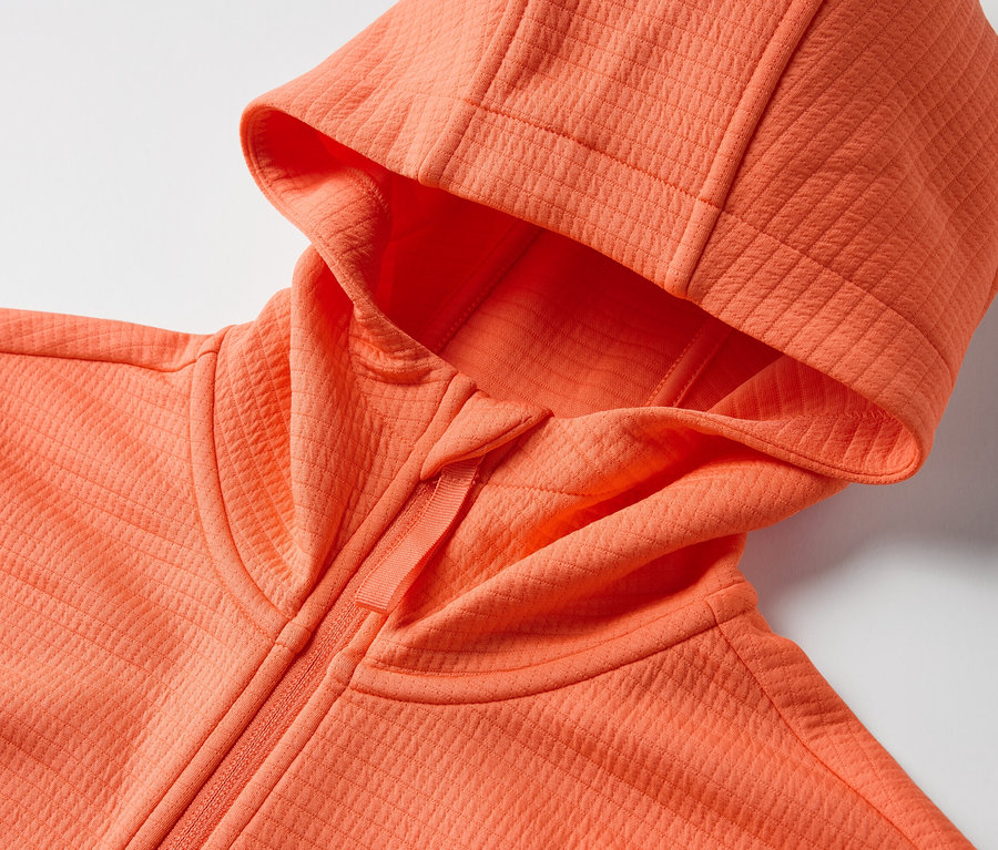 Vue détaillée d'une veste fonctionnelle orange avec capuche.