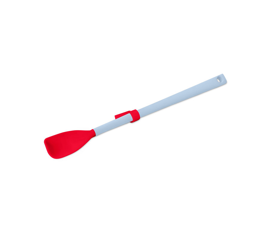 Une cuillère spéciale en silicone rouge avec un manche bleu clair repose en diagonale sur un fond blanc.