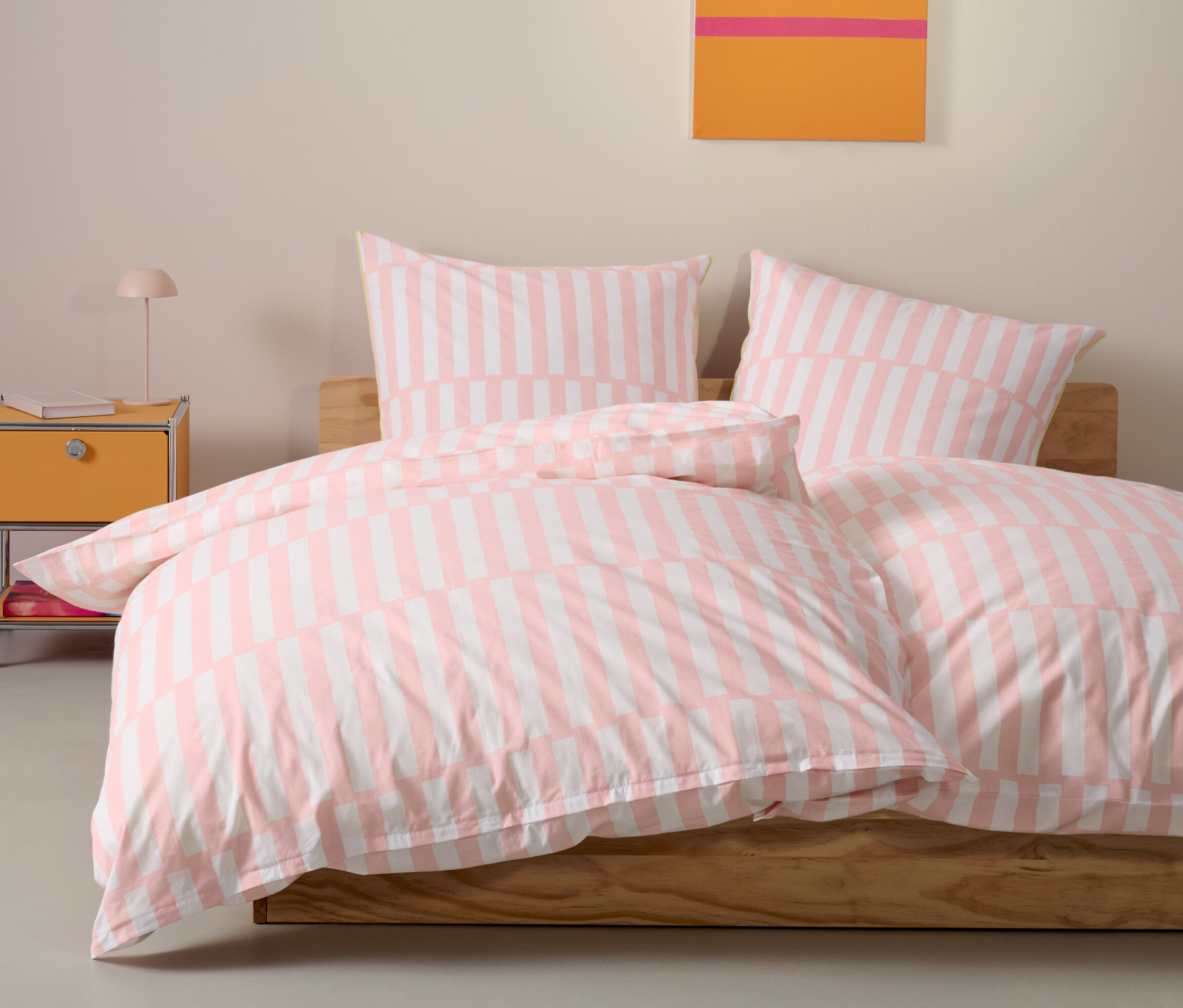 Une parure de lit en renforcé rose de taille standard est disposée sur un lit avec deux oreillers.