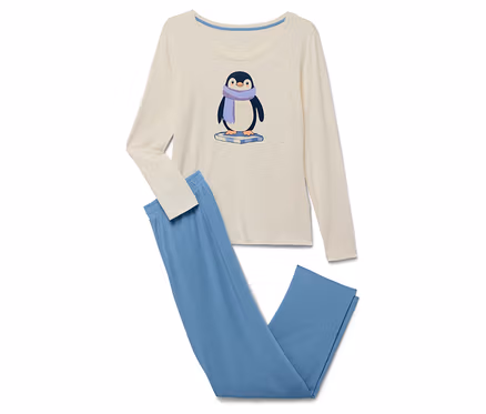 Pyjama beige à manches longues et pantalon bleu. Un pingouin avec une écharpe violette est imprimé sur le t-shirt.