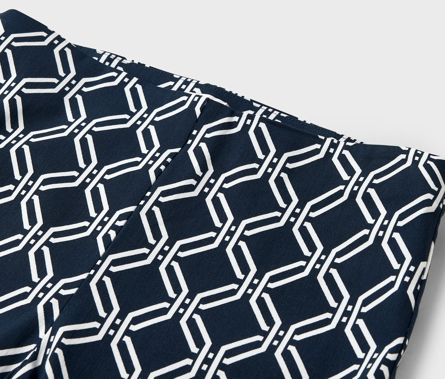 Gros plan sur un legging bleu marine avec un motif géométrique blanc.