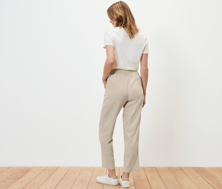 Femme vue de dos portant un pantalon en lin couleur sable.