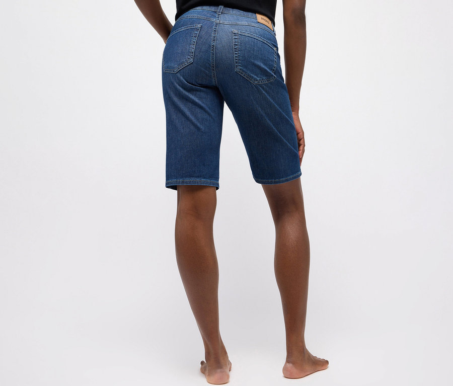 Personne vue de dos portant un jean Bermuda Turn-Up Angels bleu moyen à coupe droite, debout pieds nus.