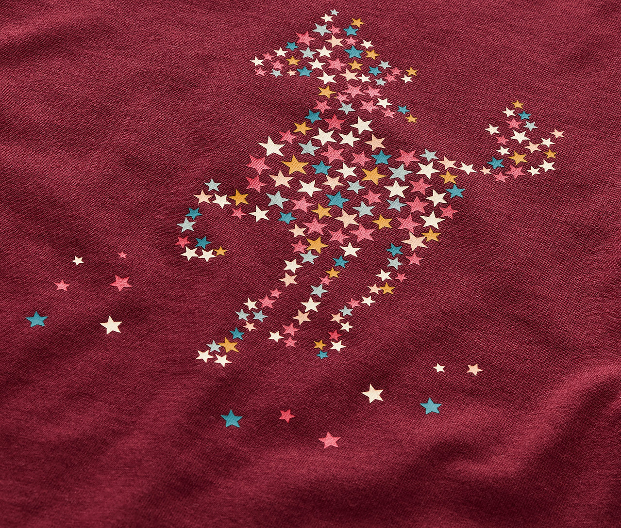 Gros plan sur un pyjama pour enfant orné d'un motif de cheval composé d'étoiles.