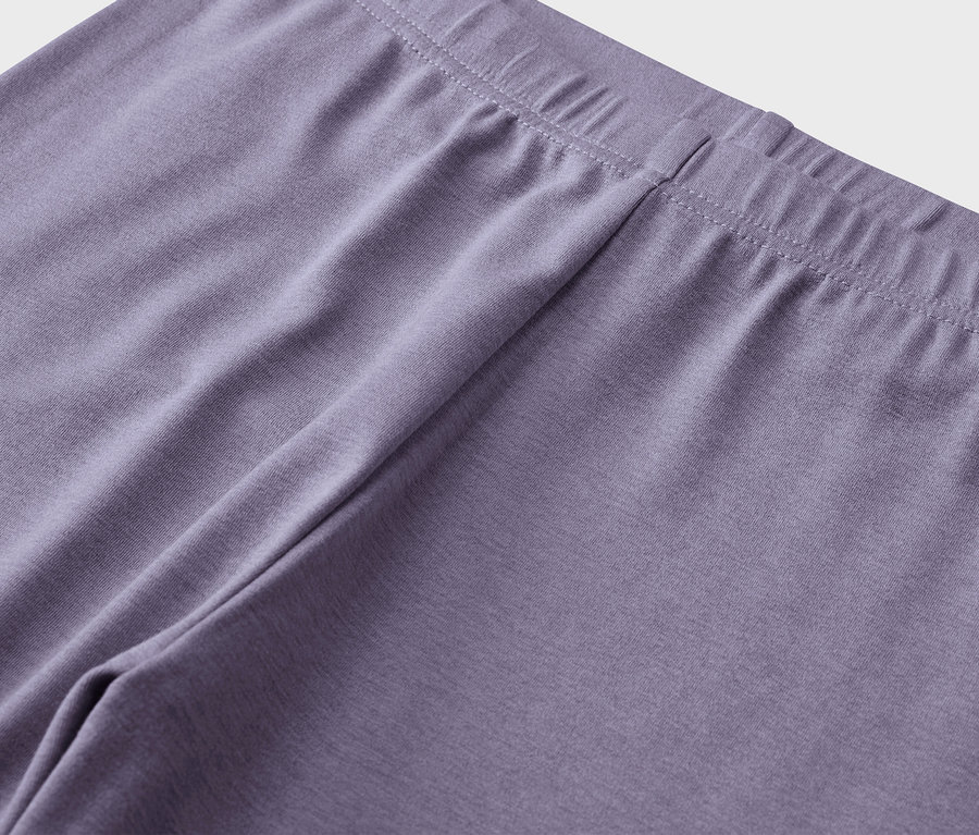 Détail de leggings violets avec une ceinture élastique.
