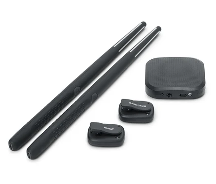 Deux baguettes de batterie noires sont placées l'une à côté de l'autre. Une boîte de son noire et deux petits pads de batterie noirs, l'un avec l'inscription BASS DRUM et l'autre avec l'inscription HI-HAT, sont également présents.