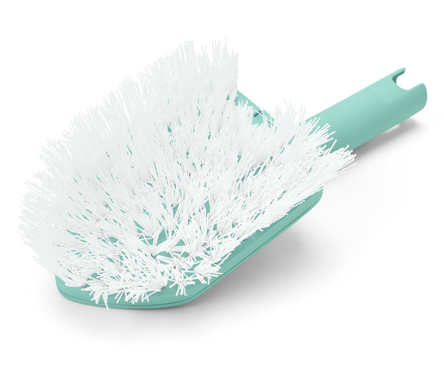 Gros plan d'une brosse blanche avec un manche vert menthe.