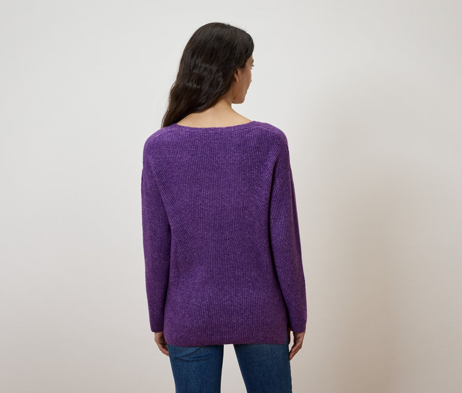 Vue arrière d'une femme aux cheveux foncés portant un pull violet et un jean bleu.