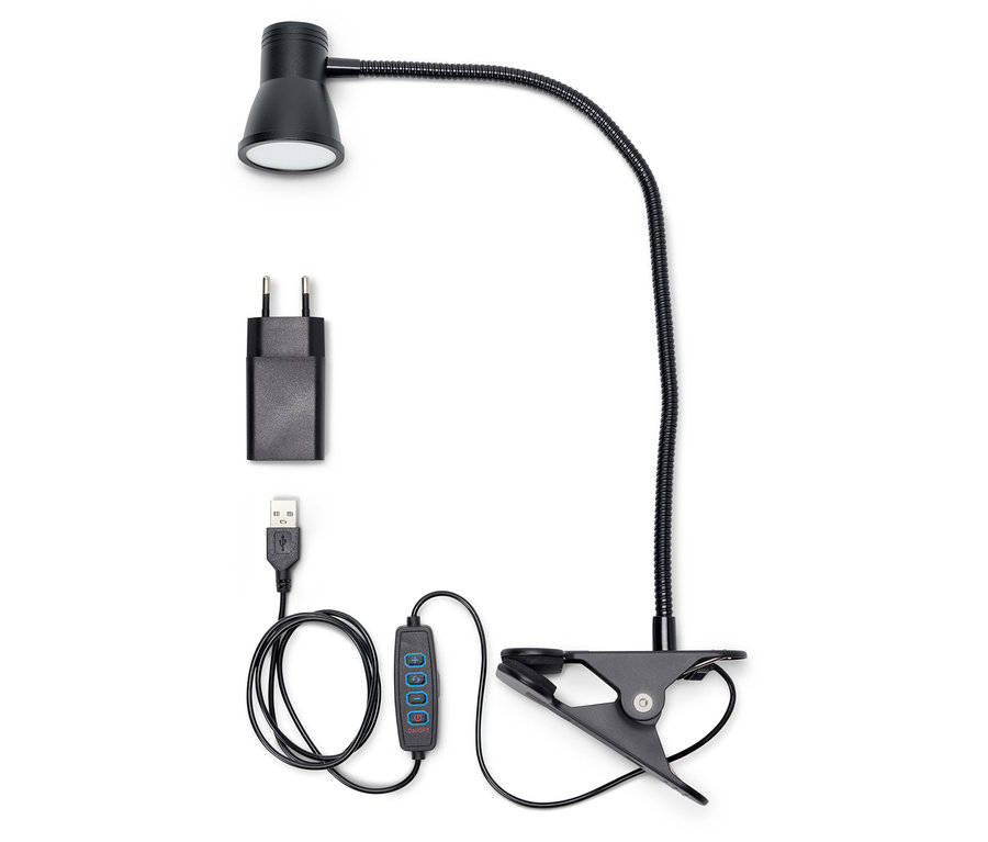 Une lampe LED noire avec pince, adaptateur et câble USB sur fond blanc.