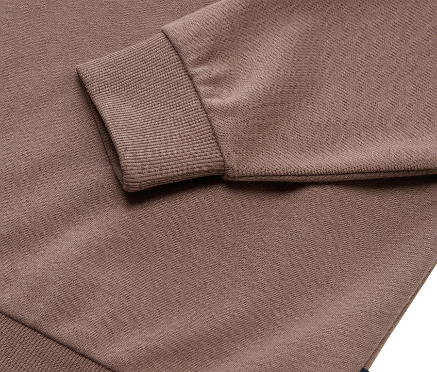 Gros plan d'un sweat-shirt Tom Tailor marron avec des poignets côtelés.