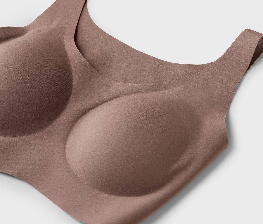 Gros plan d'un soutien-gorge couleur chair avec des bonnets moulés sur un fond blanc.