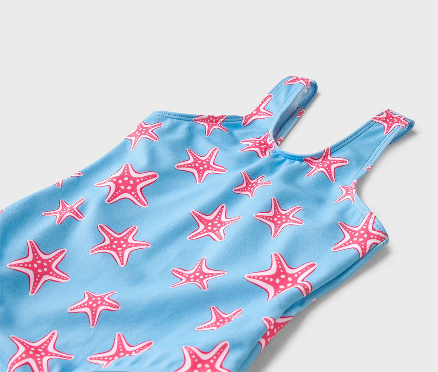 Gros plan d'un maillot de bain bleu clair avec un motif d'étoiles de mer roses.