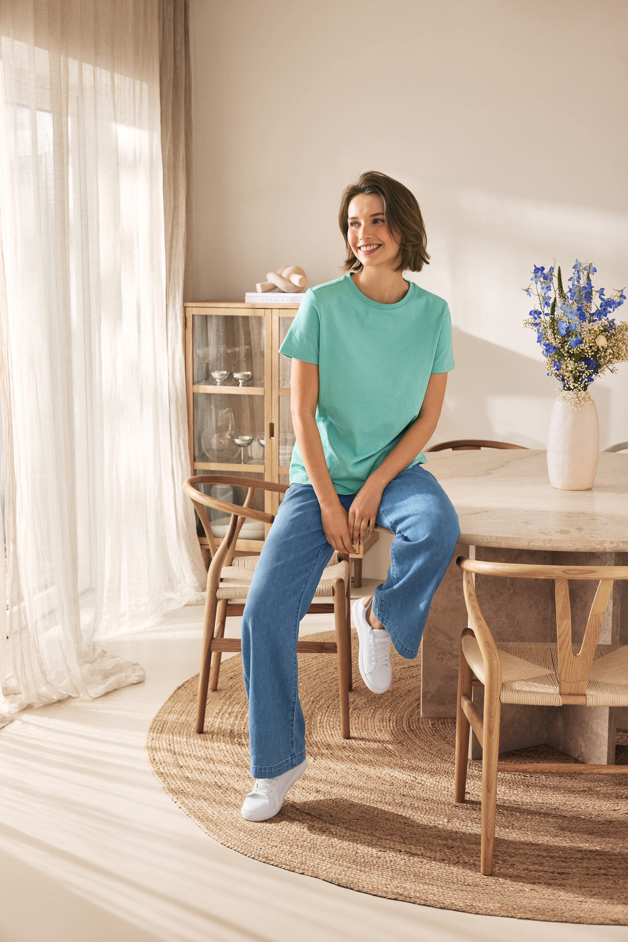 Femme assise sur une chaise portant des baskets en cuir.