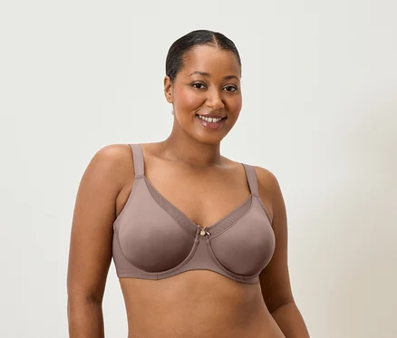 Femme souriante portant un soutien-gorge couleur mauve.
