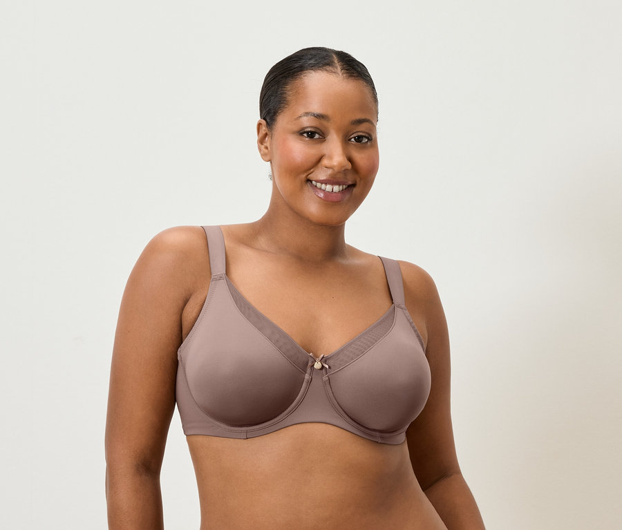 Femme souriante portant un soutien-gorge couleur mauve.
