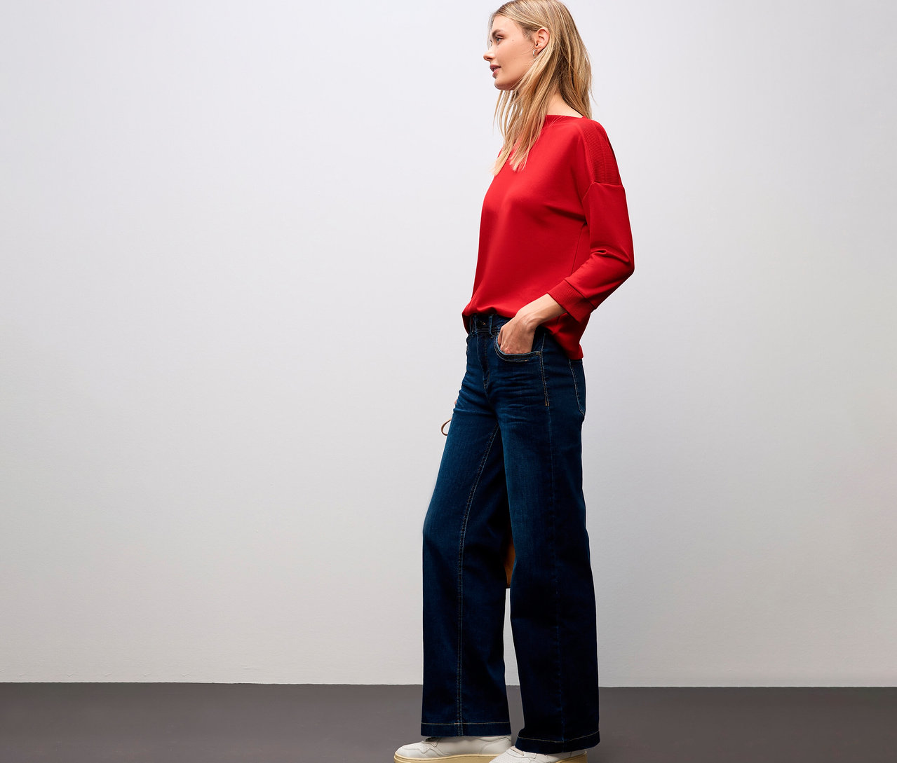 Femme portant un t-shirt rouge Street One avec des détails côtelés et un jean.