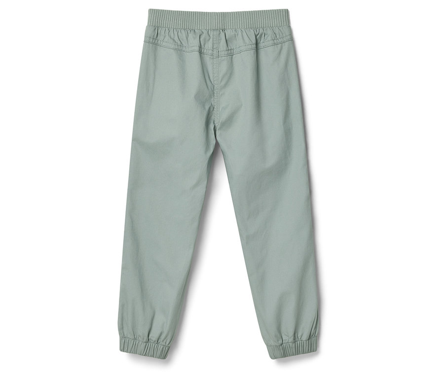 Pantalon clair avec ceinture élastique et chevilles élastiquées, photographié de dos.
