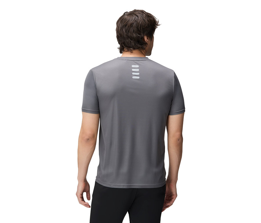 Un homme vu de dos portant un haut de sport gris et un pantalon noir.