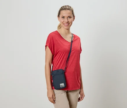 Femme portant un t-shirt rouge et un sac à bandoulière.