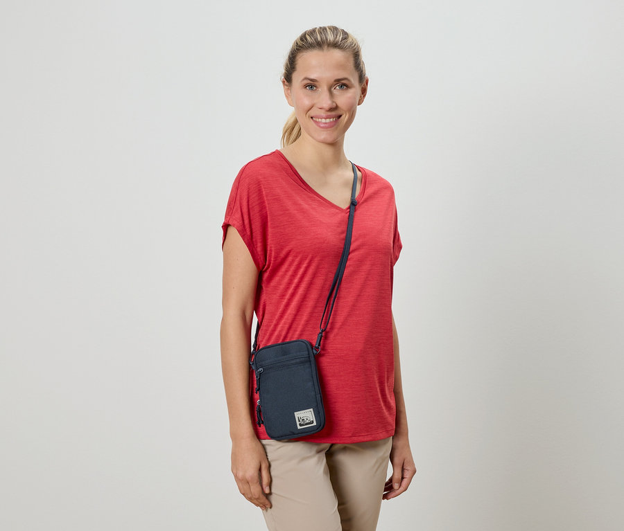 Femme portant un t-shirt rouge et un sac à bandoulière.