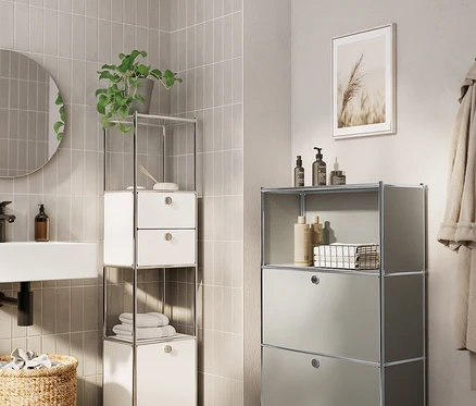 Salle de bain avec lavabo, miroir, panier tressé et deux étagères modulaires.