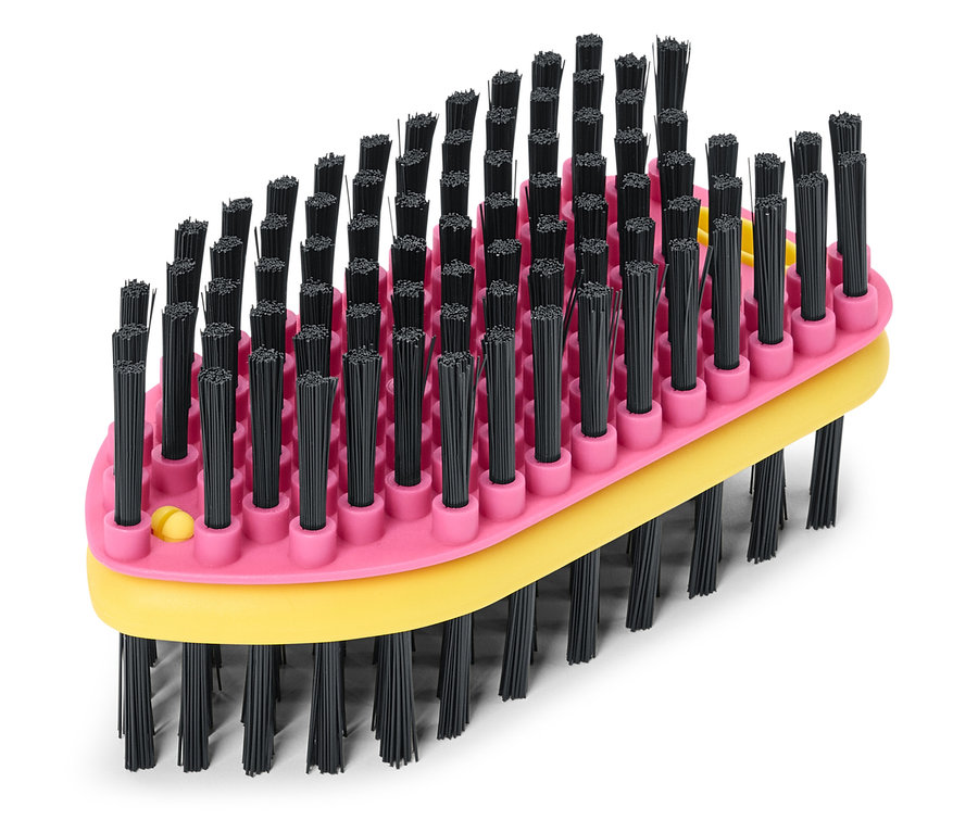 Gros plan d'une brosse rose et jaune avec des poils noirs sur fond blanc.