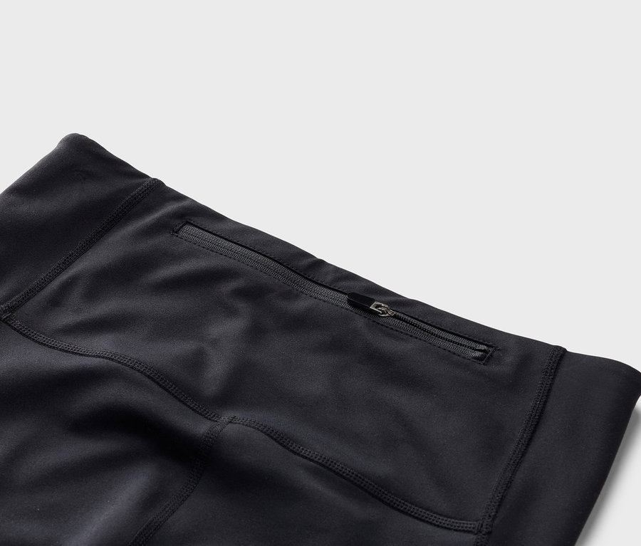 Gros plan sur un legging noir avec une poche zippée.