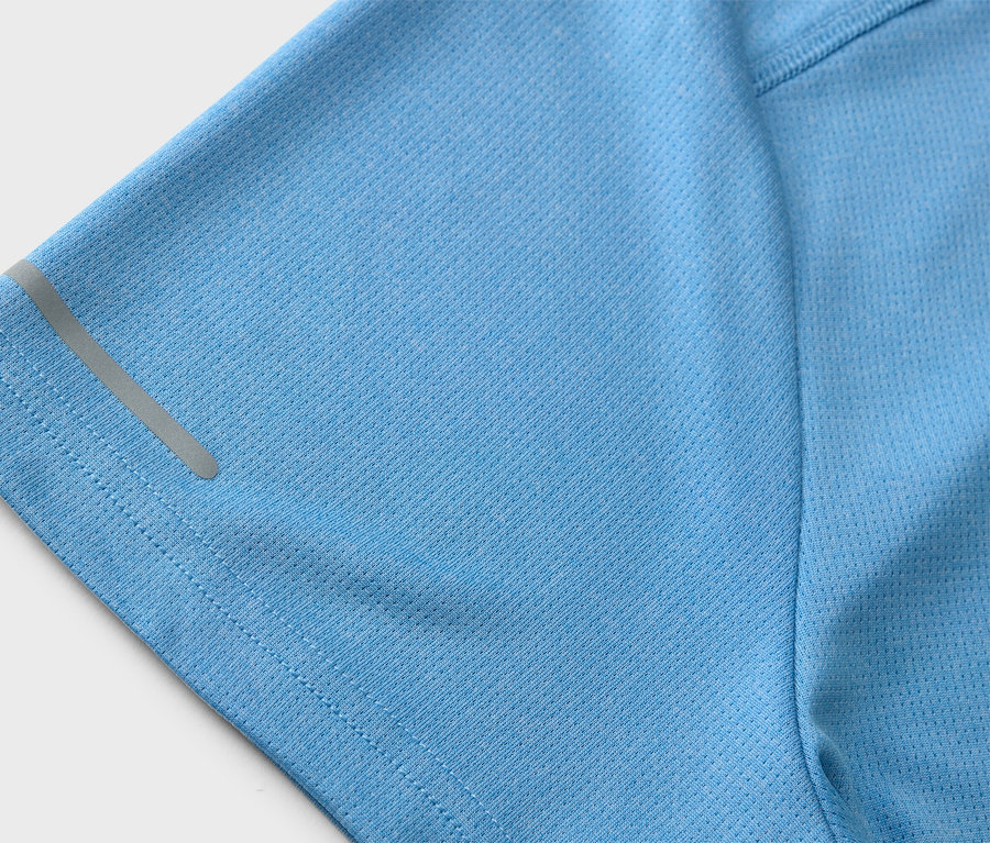 Gros plan sur un t-shirt de sport bleu clair avec une bande réfléchissante sur la manche.