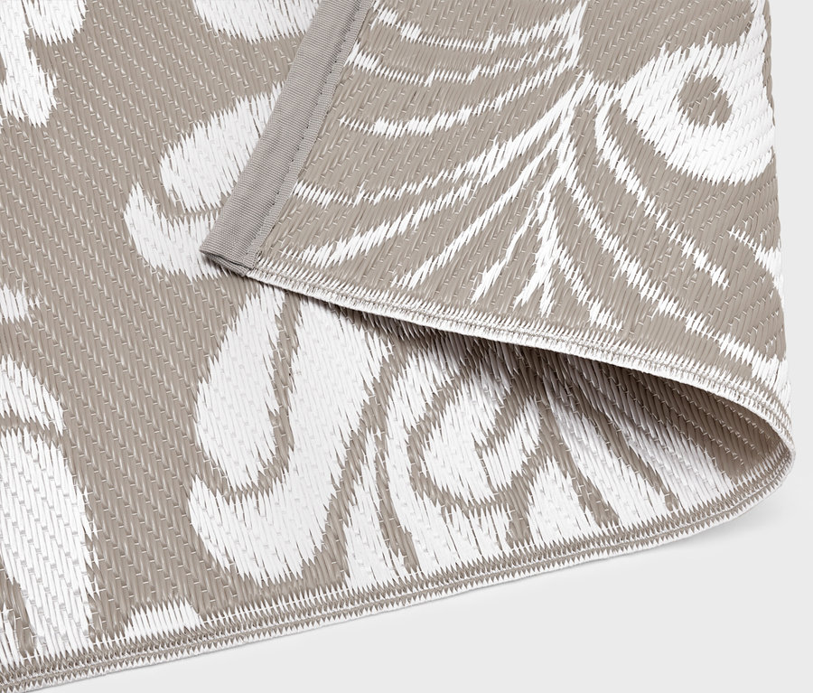 Gros plan d'un tapis d'extérieur avec un motif gris et blanc.