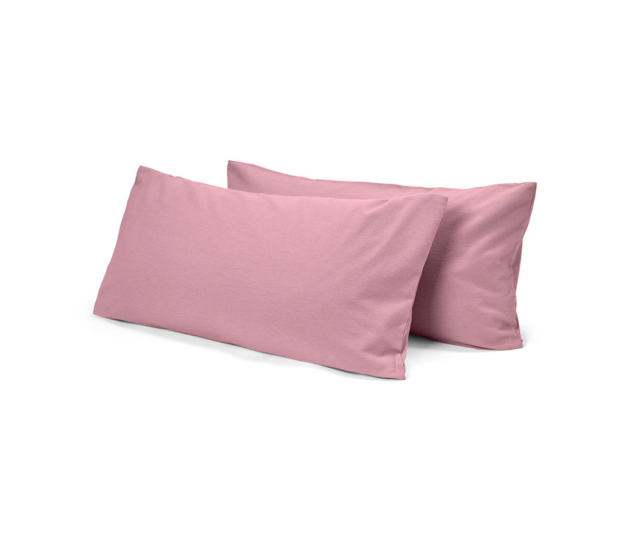 Deux oreillers roses rectangulaires, l'un légèrement derrière l'autre, sur un fond blanc.