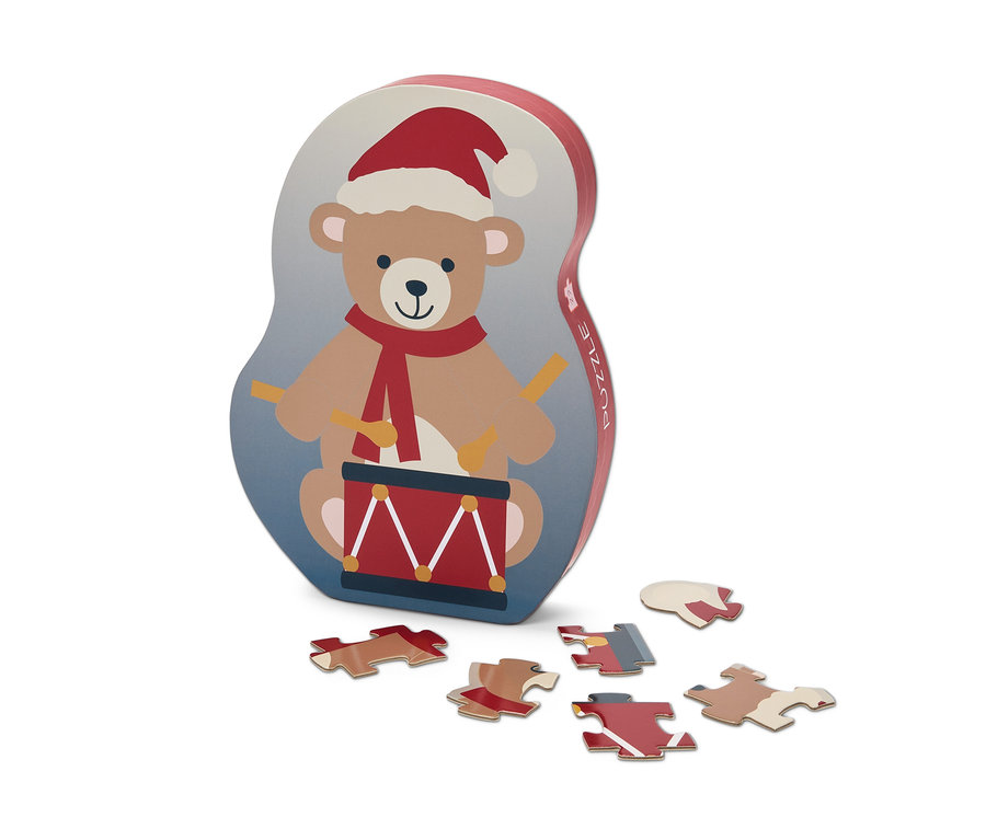 Boîte de puzzle avec un ours jouant du tambour avec un bonnet de Noël et six pièces de puzzle.
