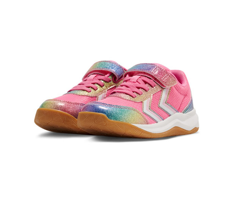 Une paire de baskets pour enfants roses avec des accents de paillettes arc-en-ciel, des rayures chevrons blanches, des lacets roses et une fermeture auto-agrippante. Elles ont une semelle intermédiaire blanche et une semelle extérieure en caoutchouc marron.