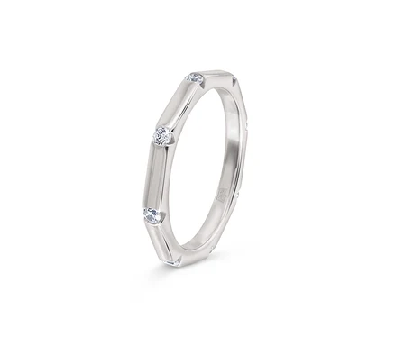 Bague argentée avec trois pierres claires serties.