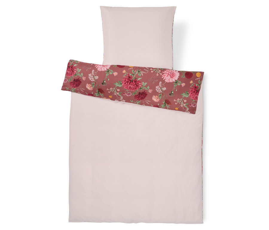 Linge de lit rose clair avec un motif floral.
