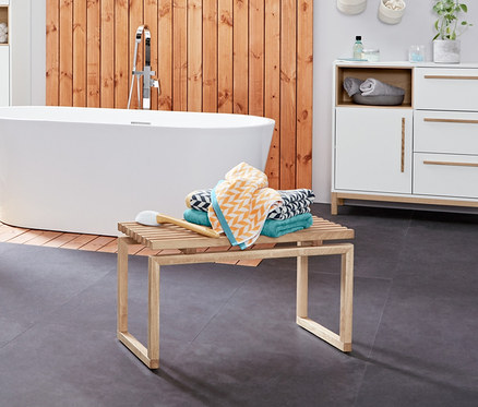 Intérieur de salle de bain avec un chariot d’appoint pour salle de bains «Eklund», buffet de salle de bains «Eklund», armoire haute pour salle de bains «Eklund» et linge de bain en jacquard.