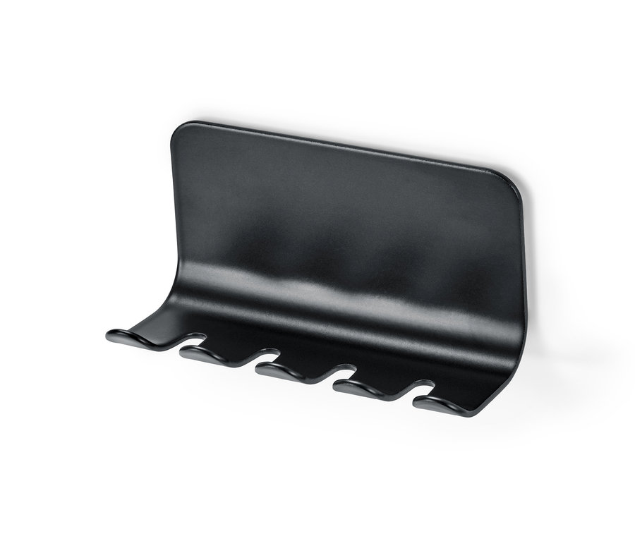 Porte-brosses à dents noir fixé sur un mur blanc.