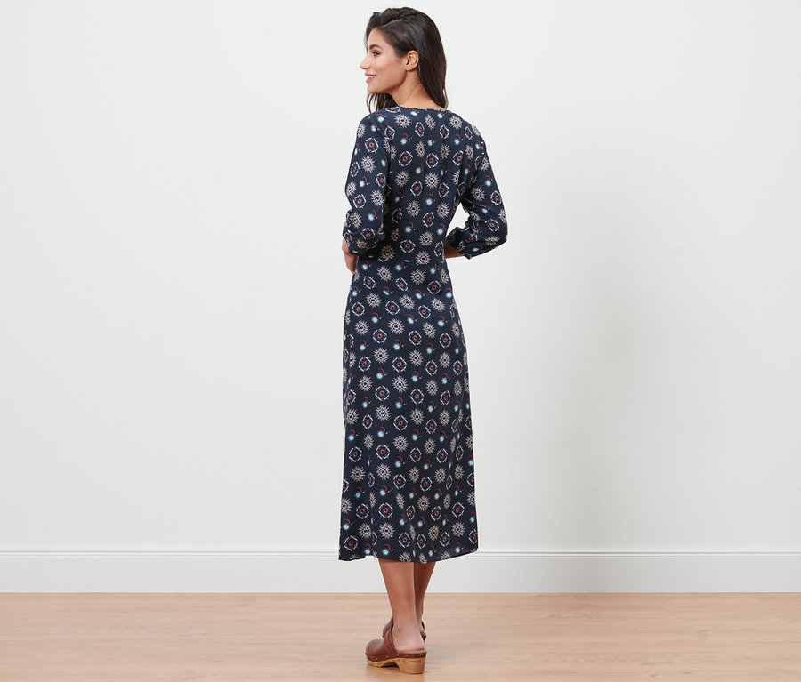 Femme posant dans une robe à imprimé.