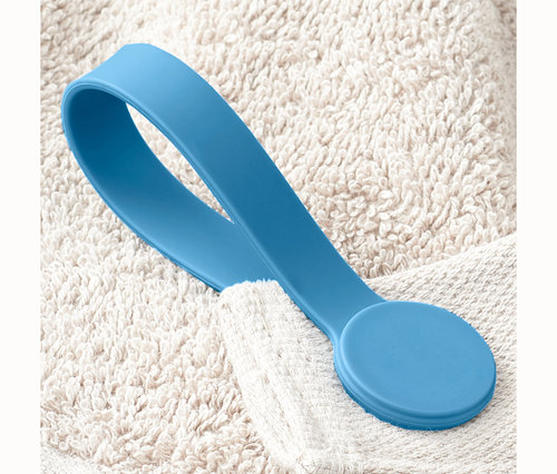 Une pince magnétique bleue sur une serviette blanche.