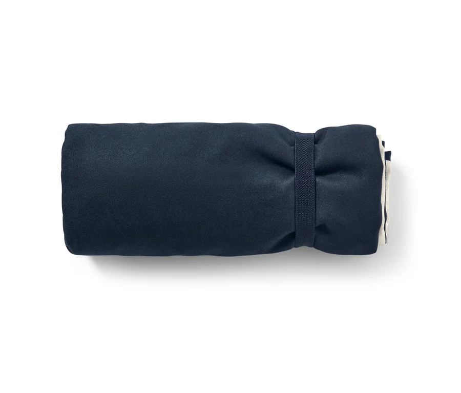 Un drap de bain en microfibre bleu marine enroulé avec housse de dossier.