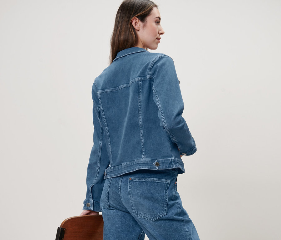 Femme de dos en veste en jean.