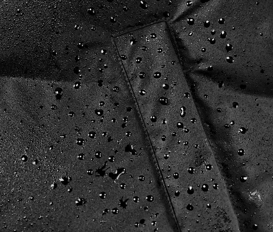 Gros plan sur un imperméable d’hiver avec des gouttes d’eau.