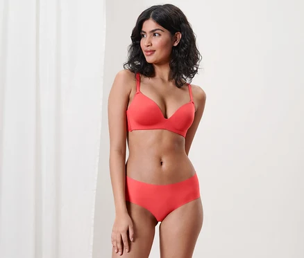 Femme posant en soutien-gorge rouge et 2 culottes Magic Cut.