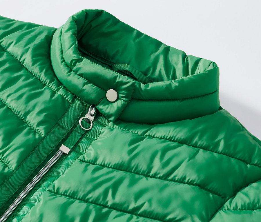 Détail d'une veste surpiquée verte.