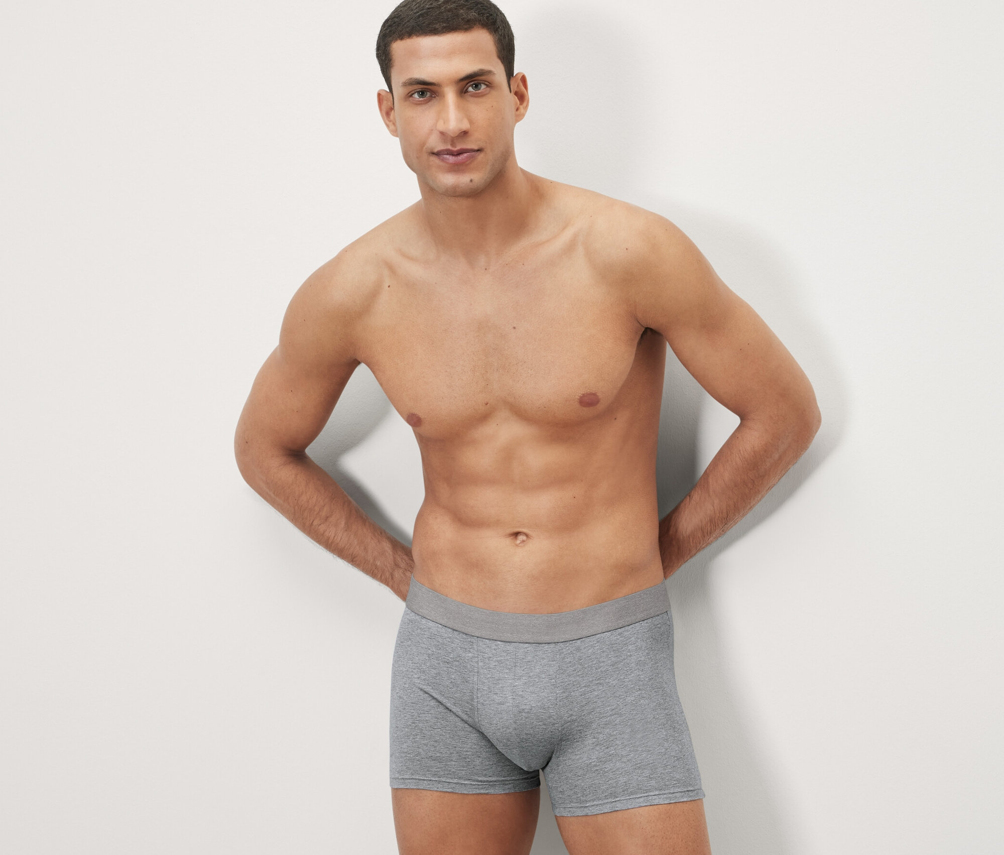 Un homme pose en 4 boxers gris.