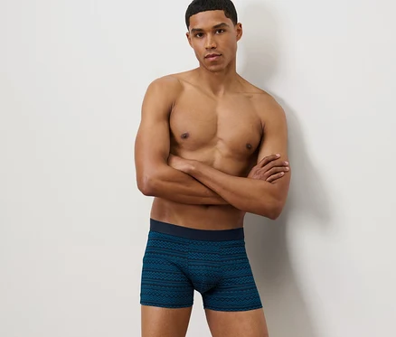 Un homme pose, les bras croisés, portant 2 boxers norvégiens.